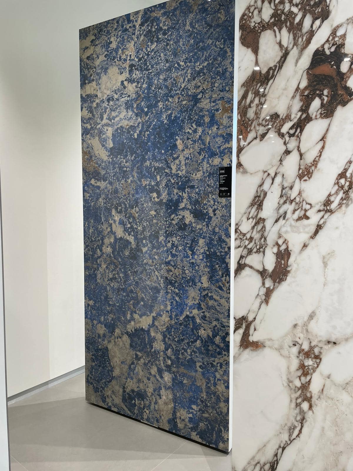 Große Platte mit blauer Marmorstruktur, daneben weiße Marmorwand mit braunen Adern.