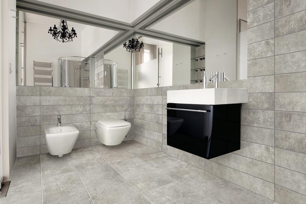 Modernes Badezimmer mit grauen Fliesen, schwebendem WC, Bidet, schwarzem Waschtisch, Spiegelwand.