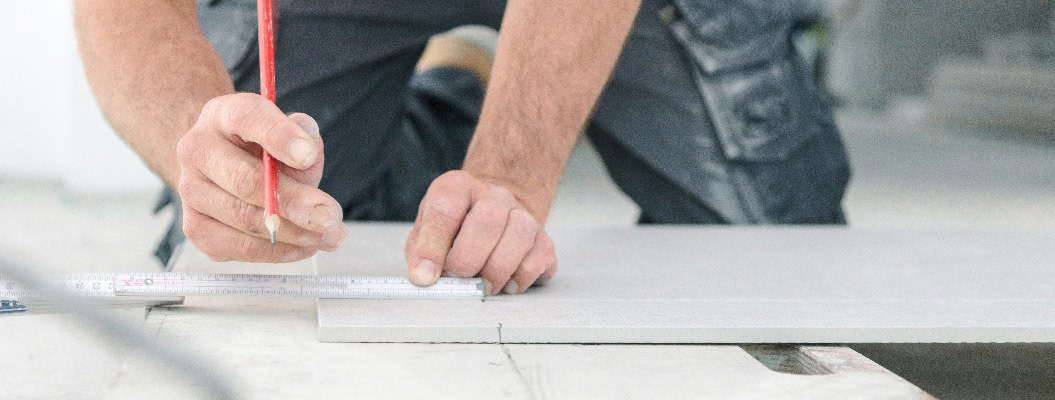 Fliesenleger bei der Arbeit , handwerker schneidet fliesen mit